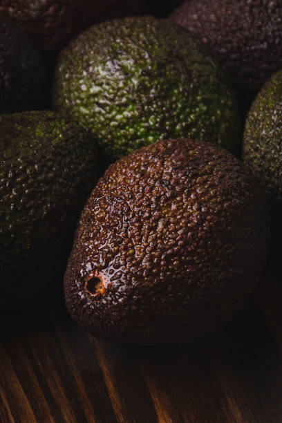 Beautiful ripe avocados on a dark wooden background.