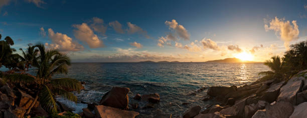 istock Tropical island sunrise idyllic ocean shore panorama 155152102