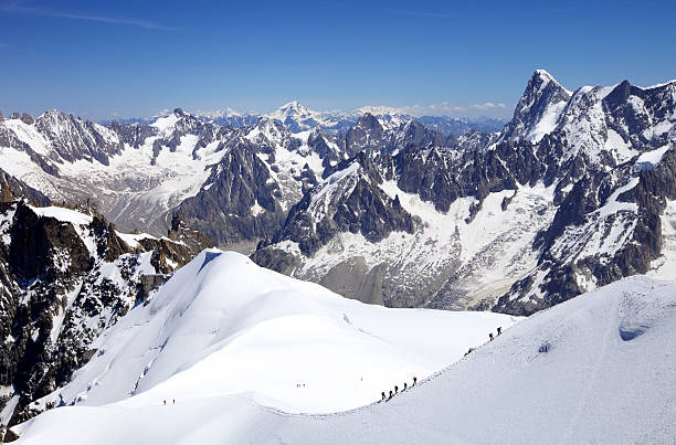 Italy. Courmayeur. Mont Blanc Region. Two climbers congratulating on the top of a peak. In the background is The Mont Blanc.