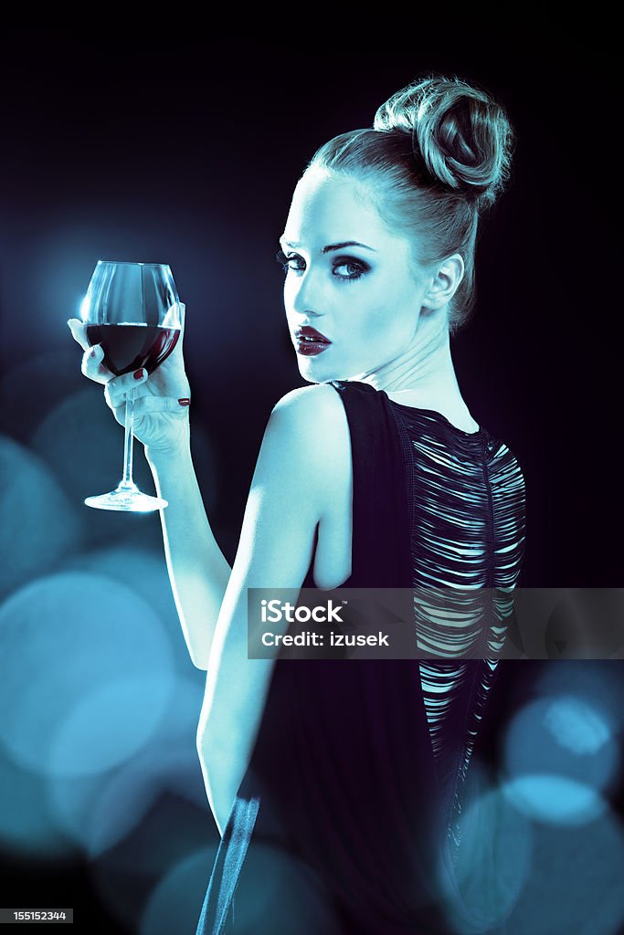 Beautiful woman in spotlights Glamour portrait of beautiful young woman wearing evening gown holding glass of wine, surrounded by spotlights.  20-24 Years Stock Photo