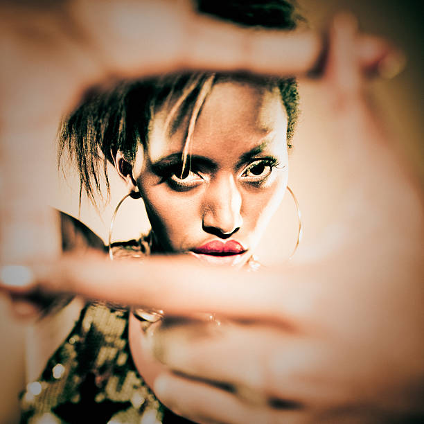 Beautiful Black Woman Posing Looking at Camera, finger frame. Tilt shift lens.