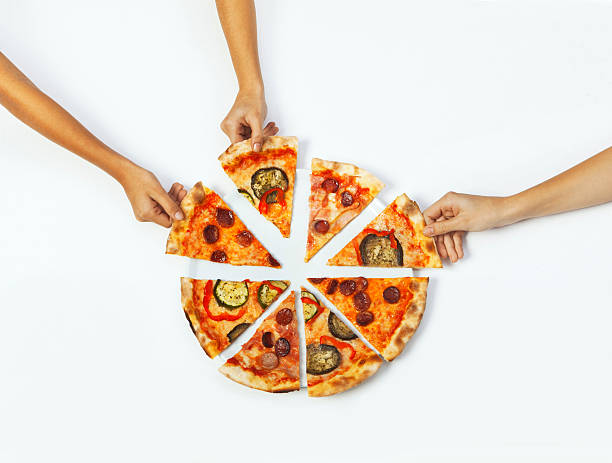 Hands picking portions of pizza stock photo