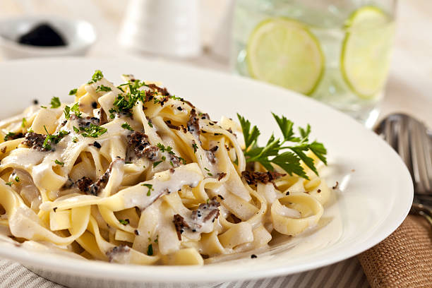 Creamy pasta with shaved truffles stock photo