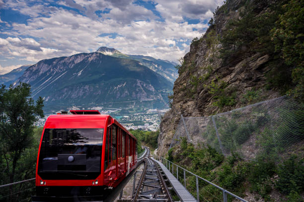 Red Swiss funicular in Switzerland. Cable car with view over Sierre city and mountain. One red Swiss funicular from Sierre to Crans Montana, Valais Canton, Switzerland. Public transport cable car with scenic view over Sierre city and mountain. crans montana stock pictures, royalty-free photos & images