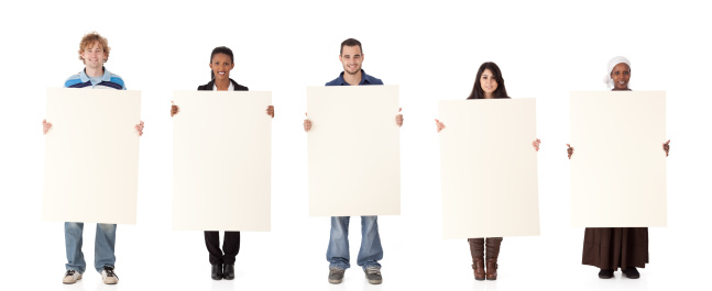 Multi ethnic five people standing in row and holding blank placard. Cut out image with a lot of copy space.