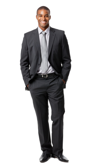 Portrait of a handsome young businessman standing with his hands in his pockets. Vertical shot. Isolated on white.