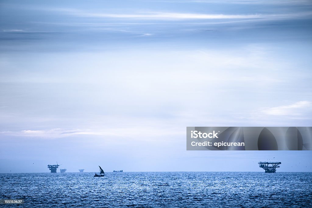 Off shore oil platforms pollute the sky line  Fishing Industry Stock Photo