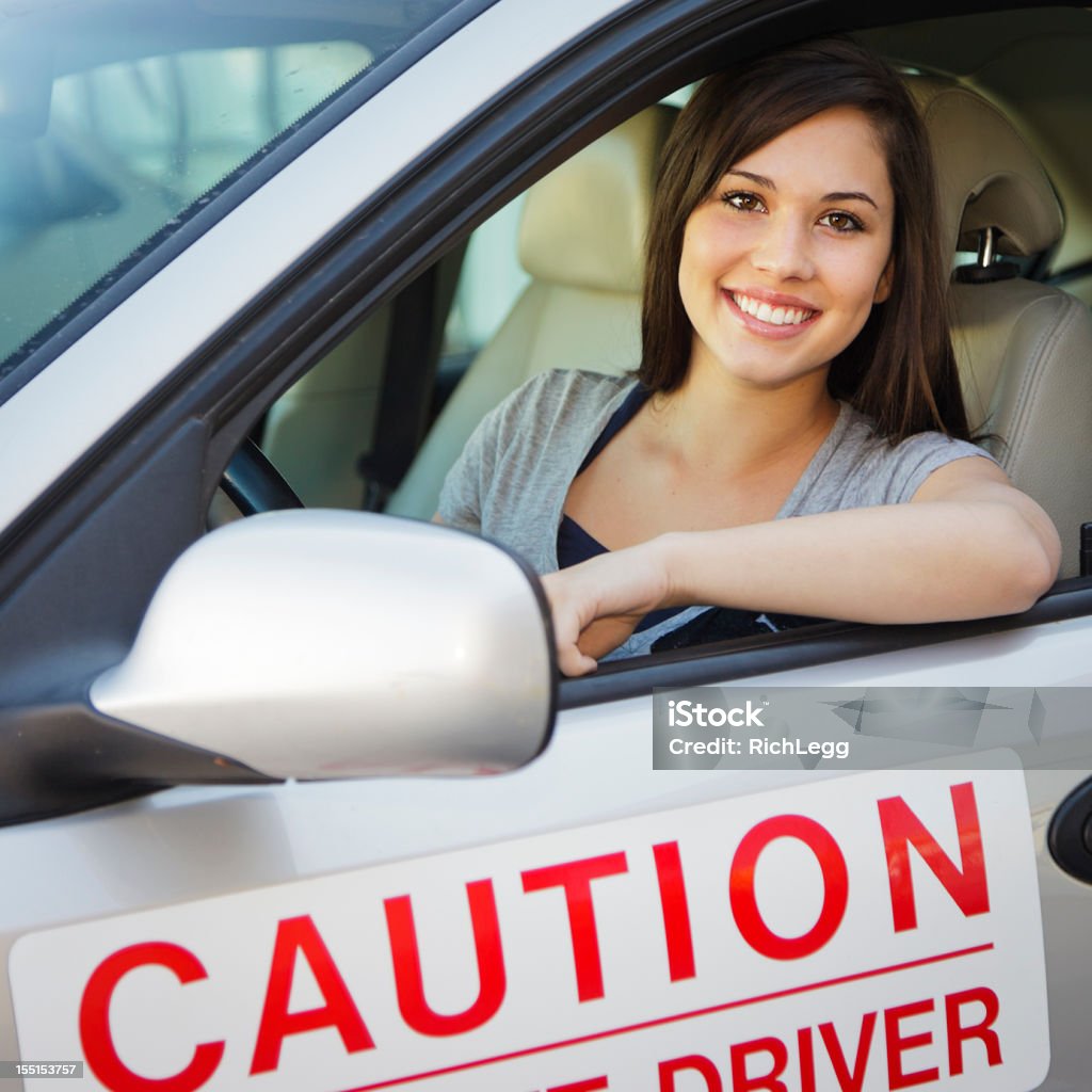 Happy Teen Driver A smiling teenage girl sitting in the driver's seat of a car. Driver - Occupation Stock Photo