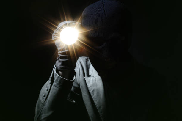 ladrão segurar a lanterna no escuro - low key imagens e fotografias de stock