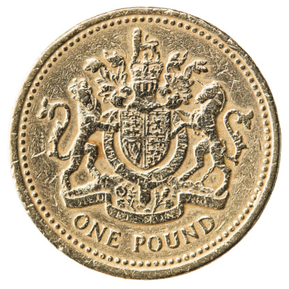 Macro photograph of a scratched and damaged one pound coin minted in 1983, featuring a royal coat of arms.