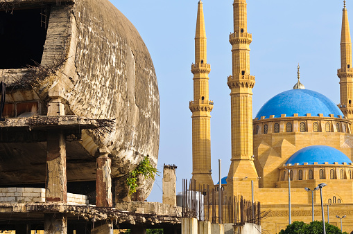 Two landmark buildings in Beirut, Lebanon. On the right is the Mohammad Al-Amin Mosque, completed in 2007. On the left is the dilapidated and bullet-scarred City Center Building, sometimes called \