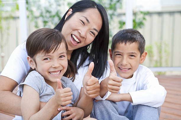 istock Mother and children sitting on deck putting thumbs up 155154259