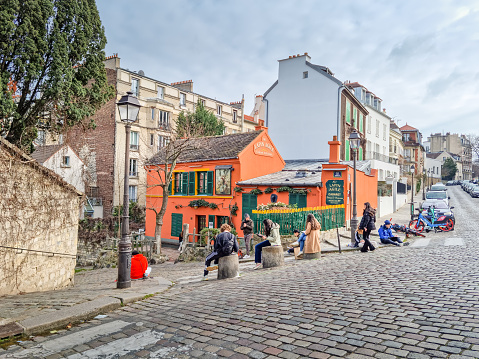 Paris, France - 6 March, 2023: Students painting a building in the Montmartre neighborhood. The traditional district is famous by its artists, cafes, restaurants and nightlife.