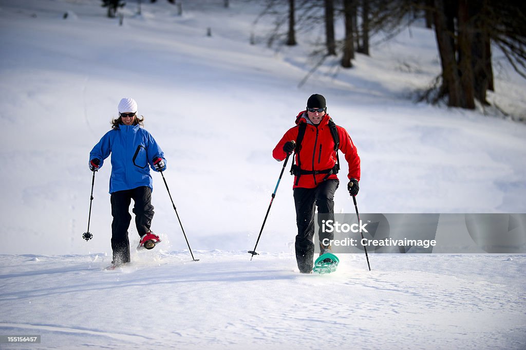 Uomo e donna con le racchette da neve - Foto stock royalty-free di Abbigliamento da sci