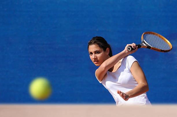 Full length portrait of young woman playing tennis isolated on white background. Healthy lifestyle. The practicing, fitness, sport, exercise concept. The female model in motion or movement