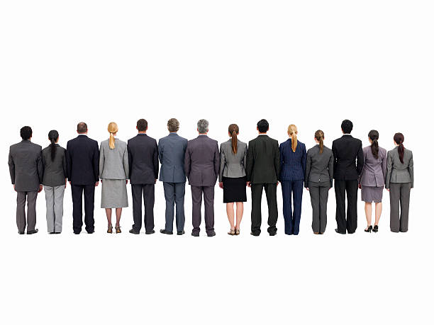 Businesspeople Standing with Backs to the Camera - Isolated Rear view of businesspeople lined up side by side. Isolated on white. Horizontal shot. people in a row photos stock pictures, royalty-free photos & images