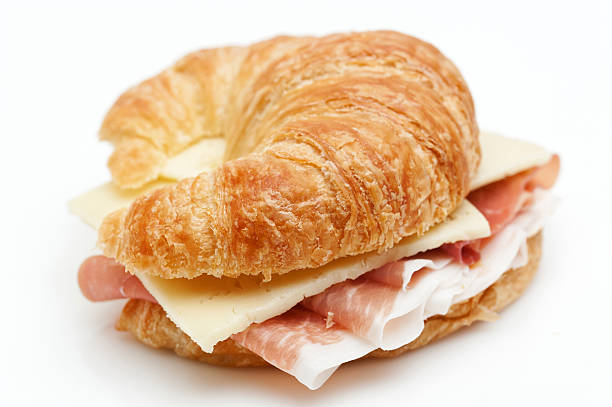 Cured Ham and Cheese Croissant Sandwich Cured Ham and Cheese Croissant Sandwich on white background close up ham and cheese sandwich stock pictures, royalty-free photos & images