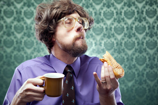 büro uncool essen donut mit kaffee - bizarre making a face men one person stock-fotos und bilder