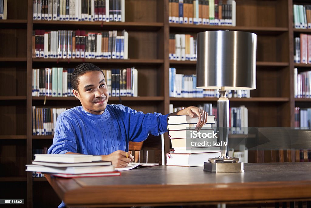 Adolescente afro-americana a estudar na biblioteca - Foto de stock de Adolescente royalty-free