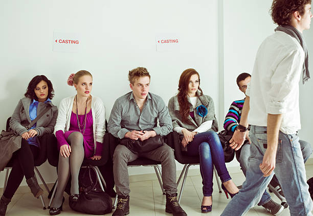 Casting call Group of serious, young adult actors or models sitting in line at casting call. actress audition stock pictures, royalty-free photos & images