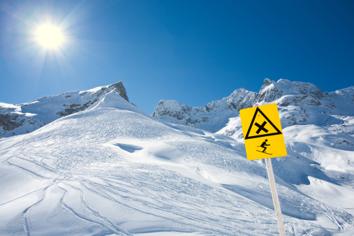 a danger of avalanches warning sign on a snowy ski area