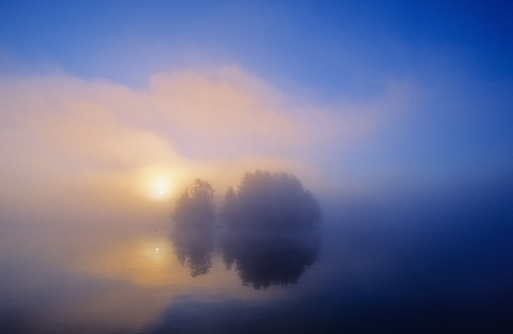 Early morning sunrise. Small island in the mist. Scanned from film.