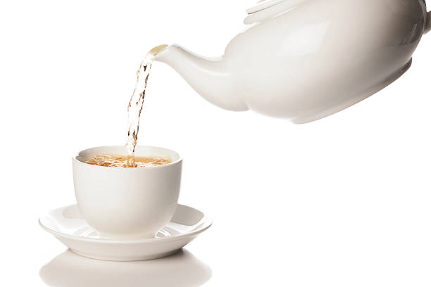 istock Pouring green tea from white teapot into a mug 155157234