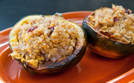 Two acorn squash halves stuffed with rice, cranberries, and onions.