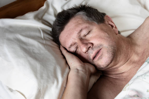 istock Mature man half asleep in bed 155157346