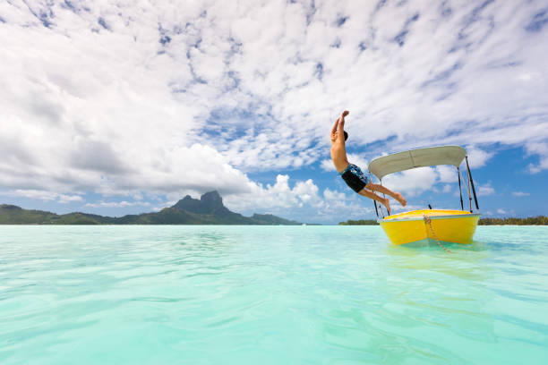istock Holidays in Paradise Boy Jumping into Bora-Bora Lagoon 155157462