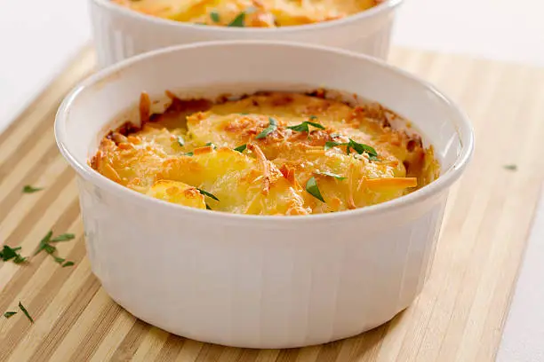 Ramekins filled with creamy, cheese topped potatoes au gratin.