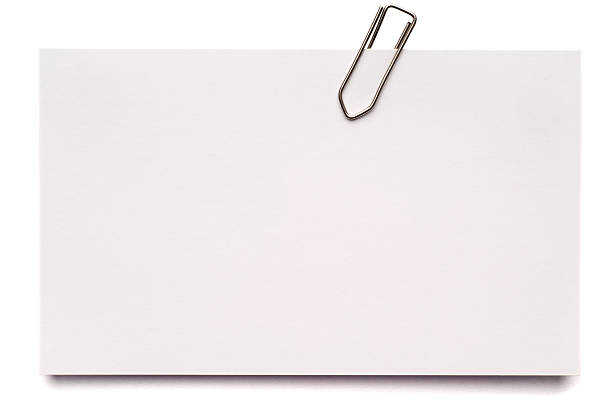 White blank index card isolated on white A blank index card with a paper clip, isolated on white. paper clip stock pictures, royalty-free photos & images