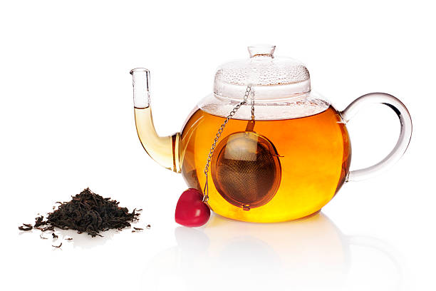 Teapot with teaball and black tea stock photo