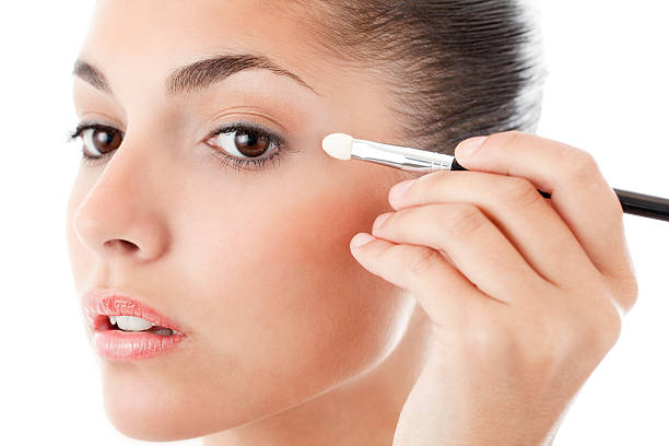 istock Young Woman Applying Eye Makeup - Isolated 155158025