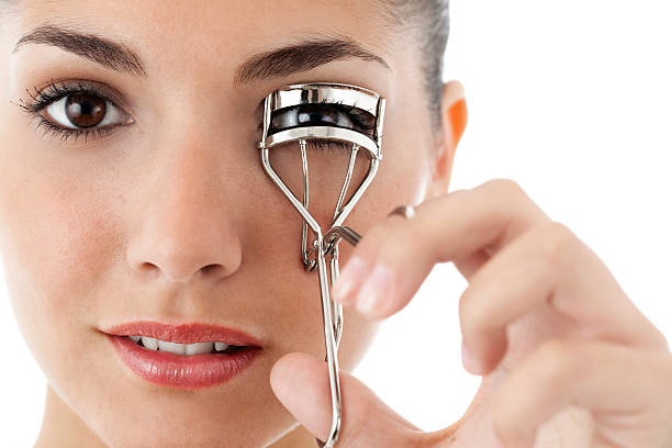 istock Young Woman Curling Her Eyelashes - Isolated 155158032