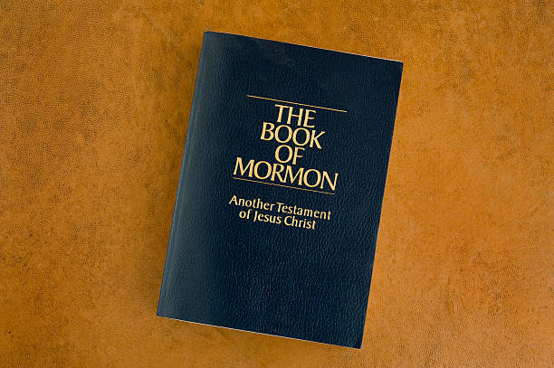 The Book of Mormon on an orange background Book of Mormon on a leather desktop. mormonism stock pictures, royalty-free photos & images