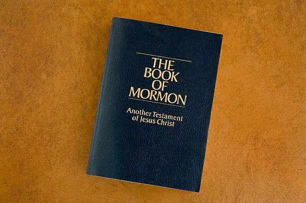 Book of Mormon on a leather desktop.