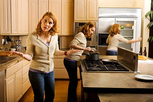 A multiple exposure of a woman in the kitchen with the woman looking directly to the camera.