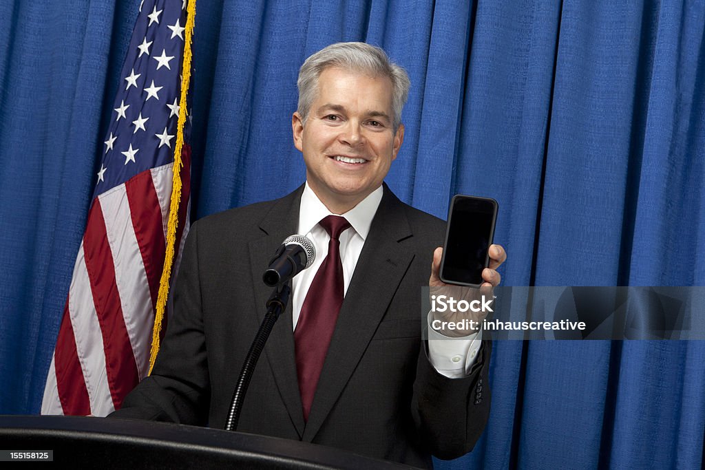 Empresario sosteniendo un teléfono inteligente - Foto de stock de Azul libre de derechos