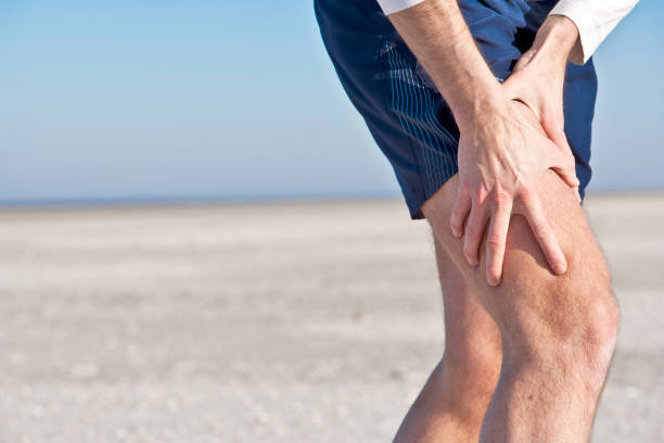 Sore muscle A male jogger with a sore muscle/ pain in his Quadriceps-muscle. Free copy space. XXL size image. hand thigh stock pictures, royalty-free photos & images