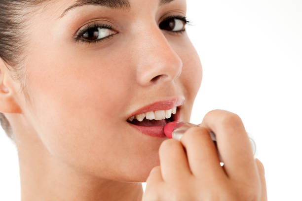 istock Young Woman Applying Lipstick - Isolated 155158270