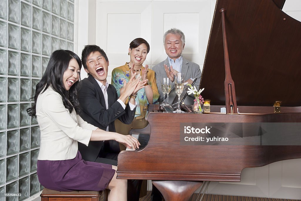 Una famiglia asiatica-suona il pianoforte - Foto stock royalty-free di Pianoforte