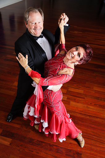 A mature couple in a ballroom dancing pose.
