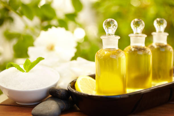Massage oil bottles at spa outdoors with pebbles and lemon and exfoliation scrub