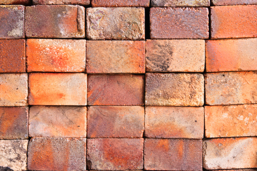 Section of an old brown brick wall.