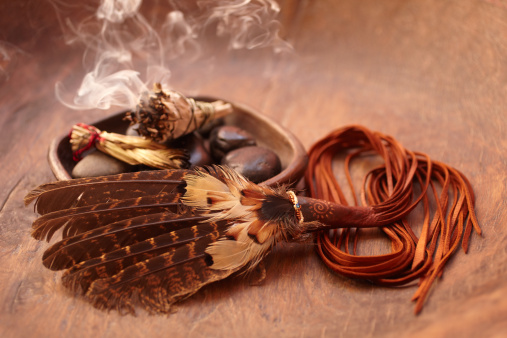 Burning incense Sage stick and american indian featherBurning incense Sage stick and pebbles