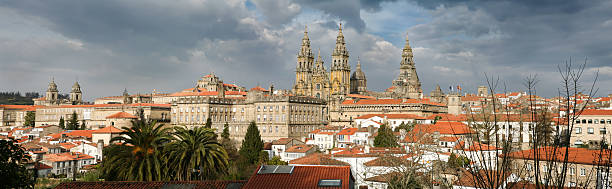 View of the city and its cathedral, framed by the natural forested hills in the background.