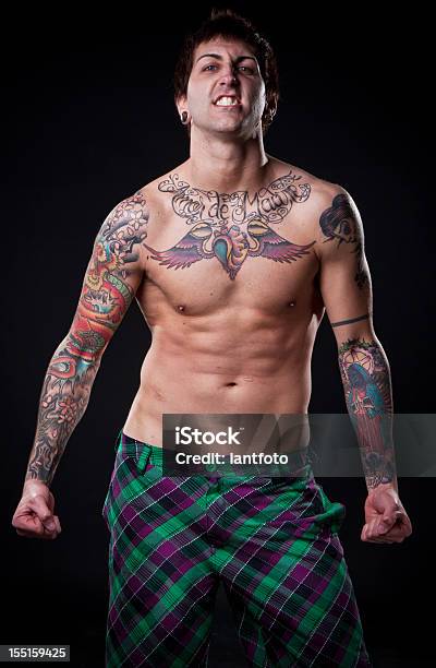 Enojado Tattooed Hombre De Flexión Sus Músculos Foto de stock y más banco de imágenes de Adulto - Adulto, Adulto joven, Atleta - Papel social