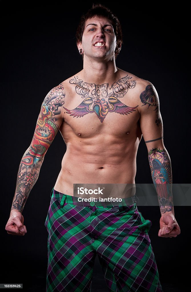 Arrabbiato tattoo uomo flettendo i Suoi muscoli. - Foto stock royalty-free di A petto nudo