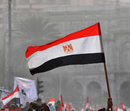 At a demonstration in Cairo's Tahrir Square, an Egyptian flag is raised above the crowd.